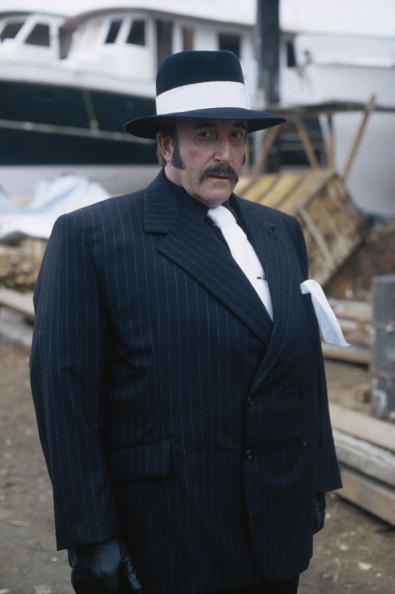 British comic actor Peter Sellers (1925 - 1980) in disguise as a gangster during filming of 'The Revenge of the Pink Panther', directed by Blake Edwards, 1978. The film marked Sellers' last appearance as Inspector Jacques Clouseau. (Photo by Graham Stark/Hulton Archive/Getty Images)